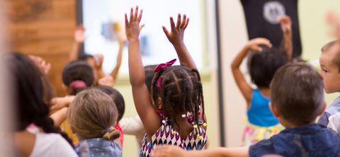 Kinder heben die Haende